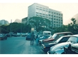 cg0048_072 - Na entrada da PUC, os carros  eram estacionados no espaço onde hoje existe o terminal de ônibus, ao fundo os prédios Frings e Kennedy. Fotógrafo desconhecido. Acervo Núcleo de Memória, 1992.