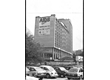 cg0050_059 - Carros dividem a foto com o cartaz do Primeiro Simpósio da AIDS na PUC-Rio, preso no alto do edifício Cardeal Leme. Fotógrafo desconhecido. 1989.
