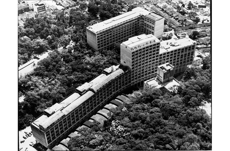 Vista aérea do campus Gávea, com o ITUC, o laboratório Van de Graaff, o Edifício Cardeal Leme, o antigo ginásio esportivo, o Edifício da Amizade e ao fundo, à direita, o Parque Proletário da Gávea. c. 1974. Fotógrafo desconhecido. Acervo Núcleo de Memória.