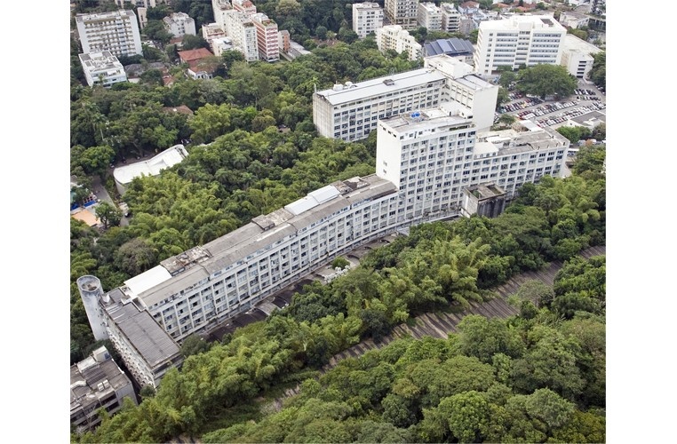 Vista aérea do campus Gávea, com o túnel acústico em primeiro plano, o Rio Datacentro à esquerda, o ITUC, o laboratório Van de Graaff, o Edifício Cardeal Leme, a Igreja do Sagrado Coração de Jesus, o Edifício da Amizade, o Ginásio Poliesportivo, o Edifício Padre Laércio Dias de Moura e o estacionamento. 2010. Fotógrafo Nilo Lima. Acervo Núcleo de Memória. Vista aérea do campus Gávea, com o túnel acústico em primeiro plano, o Rio Datacentro à esquerda, o ITUC, o laboratório Van de Graaff, o Edifício Cardeal Leme, a Igreja do Sagrado Coração de Jesus, o Edifício da Amizade, o Ginásio Poliesportivo, o Edifício Padre Laércio Dias de Moura e o estacionamento. 2010. Fotógrafo Nilo Lima. Acervo Núcleo de Memória.
