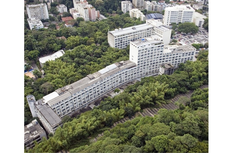 Vista aérea do campus Gávea, com o túnel acústico em primeiro plano, o Rio Datacentro à esquerda, o ITUC, o laboratório Van de Graaff, o Edifício Cardeal Leme, a Igreja do Sagrado Coração de Jesus, o Edifício da Amizade, o Ginásio Poliesportivo, o Edifício Padre Laércio Dias de Moura e o estacionamento. 2010. Fotógrafo Nilo Lima. Acervo Núcleo de Memória.