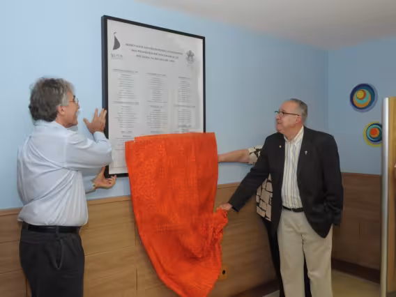 O Reitor Prof. Pe. Josafá S.J. descerra a placa no hall da Biblioteca Central ao lado do Vice-Reitor Acadêmico Prof. José Ricardo Bergmann. Fotógrafo Antônio Albuquerque. Acervo do Núcleo de Memória.