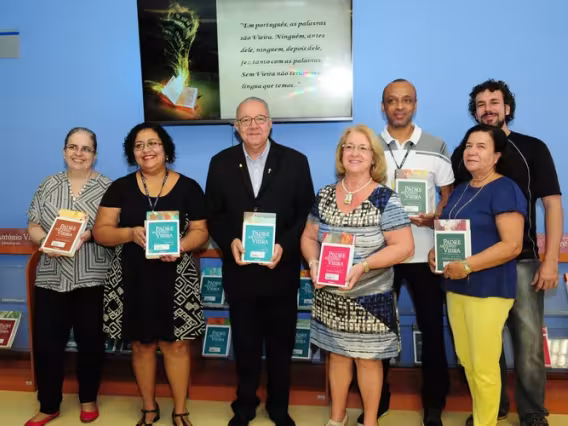 O Reitor Pe. Josafá S.J., a diretora da DBD, Sra. Dolores Rodriguez Perez e funcionários da DBD com volumes da obra do Padre Antonio Vieira. Fotógrafo Antônio Albuquerque. Acervo Núcleo de Memória.