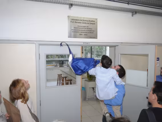 Os filhos do Prof. Reinaldo Calixto descerram juntos a placa com a homenagem. Fotógrafo Antônio Albuquerque. Acervo do Núcleo de Memória.