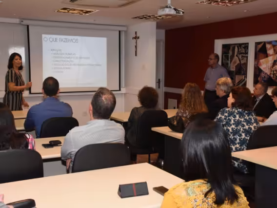 Apresentação da gerente da CAPLH, Profa. Gisele Tonietto. O evento, realizado na sala de reuniões do Decanato do CTC, contou com a presença do Reitor Pe. Josafá Carlos de Siqueira S.J. (à direita, sentado). Fotógrafo Antônio Albuquerque.