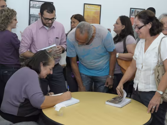 A Profa. Maria Clara Bingemer autografa seu livro. Fotógrafo Antônio Albuquerque. Acervo do Núcleo de Memória.