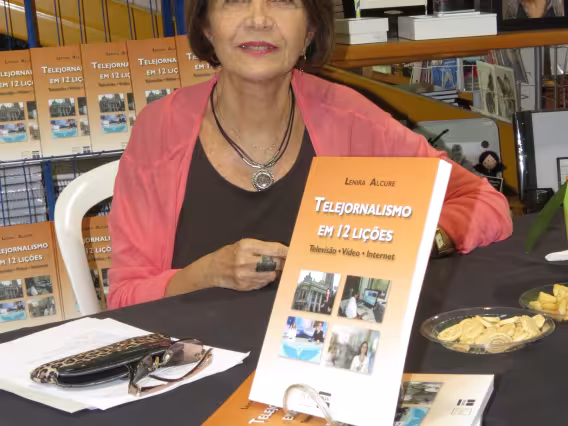 A profa. Lenira Alcure com o seu livro durante o lançamento. Fotógrafo Antônio Albuquerque. Acervo do Núcleo de Memória.
