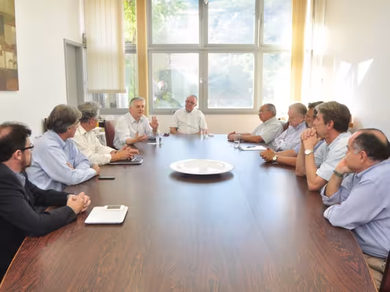 Na cabeceira da mesa o Reitor Prof. Padre Josafá Carlos de Siqueira S.J. e à sua direita o Padre Mieczyslaw Smyda S.J. Fotógrafo Weiler Filho. Acervo do Projeto Comunicar.