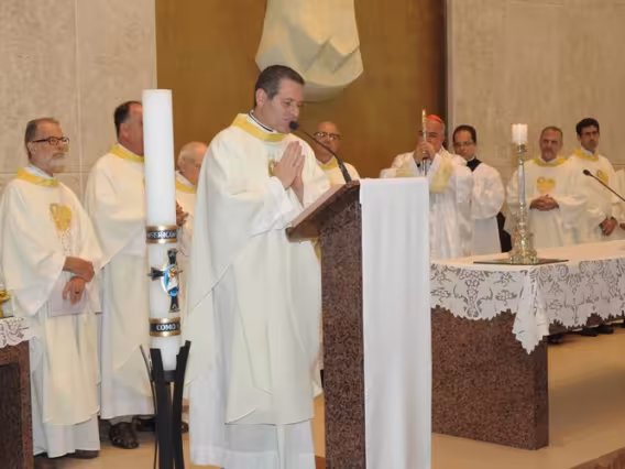 O Padre Alexandre Paciolli, e, ao fundo, o Reitor Pe. Josafá S.J. e o Arcebispo Dom Orani. Fotógrafo Antônio Albuquerque. Acervo Núcleo de Memória.