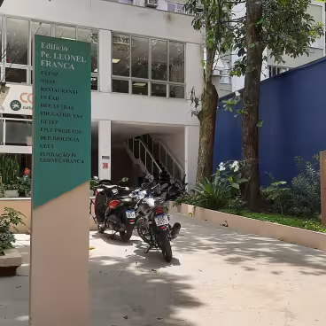 Entrada do Edifício Padre Leonel Franca, com o medalhão em homenagem ao pe. Franca à direita. 2025. Fotógrafo Antônio Albuquerque. Acervo do Núcleo de Memória da PUC-Rio.