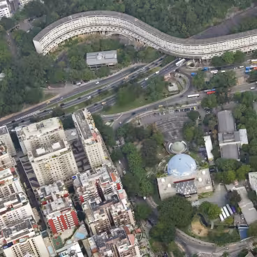 Vista da aérea da Gávea. Ao centro, em azul e verde, as duas cúpulas principais do Planetário. Na parte superior, o Minhocão, e no alto à direita os prédios da PUC-Rio. 2010. Fotógrafo Nilo Lima. Acervo Núcleo de Memória da PUC-Rio.