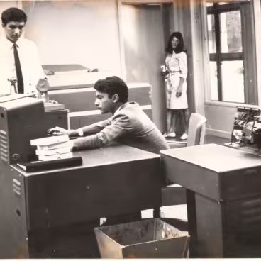 Pesquisadores operam o computador Burroughs 205 na sala do Centro de Processamento de Dados, localizada no pilotis do Edifício Central. 1965. Fotógrafo desconhecido. Acervo Núcleo de Memória da PUC-Rio.