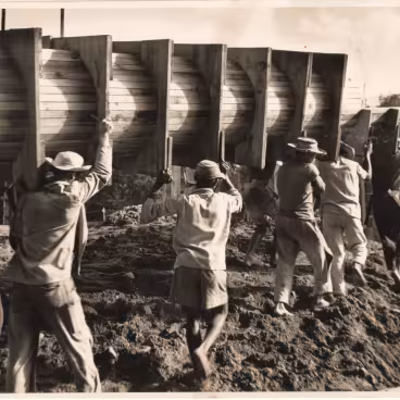 Trabalhadores carregam uma das fôrmas dos pilotis do Edifício Central, pilares físicos e simbólicos da Universidade. 1953. Fotógrafo desconhecido. Acervo Núcleo de Memória da PUC-Rio.