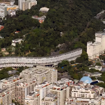 Foto aérea em que se destaca o Conjunto Habitacional Marquês de São Vicente (Minhocão), a PUC-Rio e a cúpula do Planetário da Gávea (em azul). 2010. Fotógrafo Nilo Lima. Acervo do Núcleo de Memória da PUC-Rio.